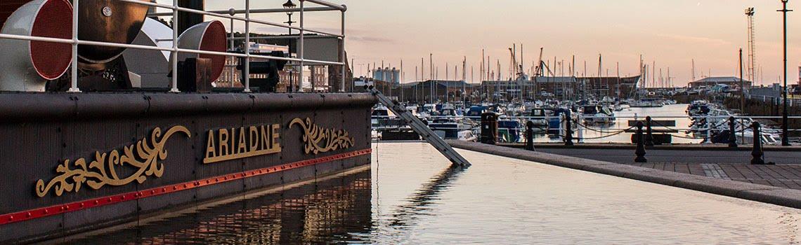 Photo of Jersey steam clock at sunset with view of harbour